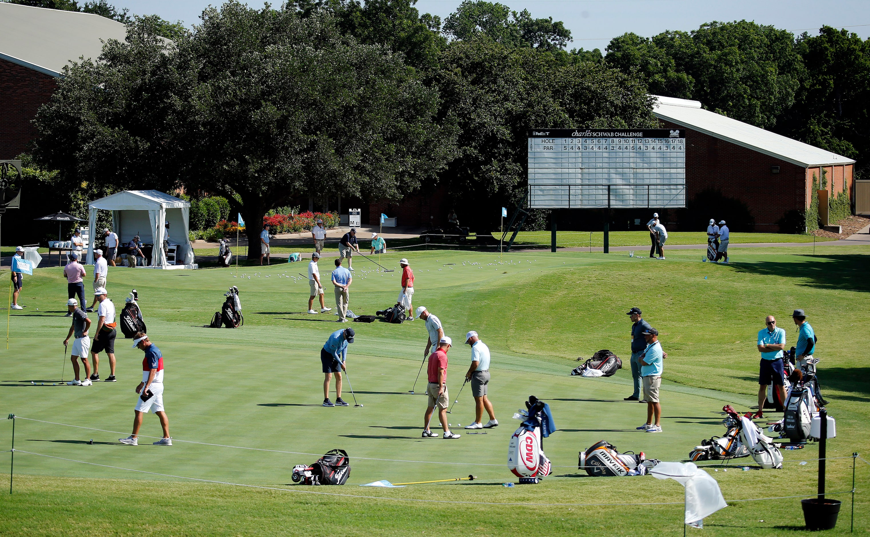 PGA golfers work on their putting and chipping around the practice greens during the Charles...