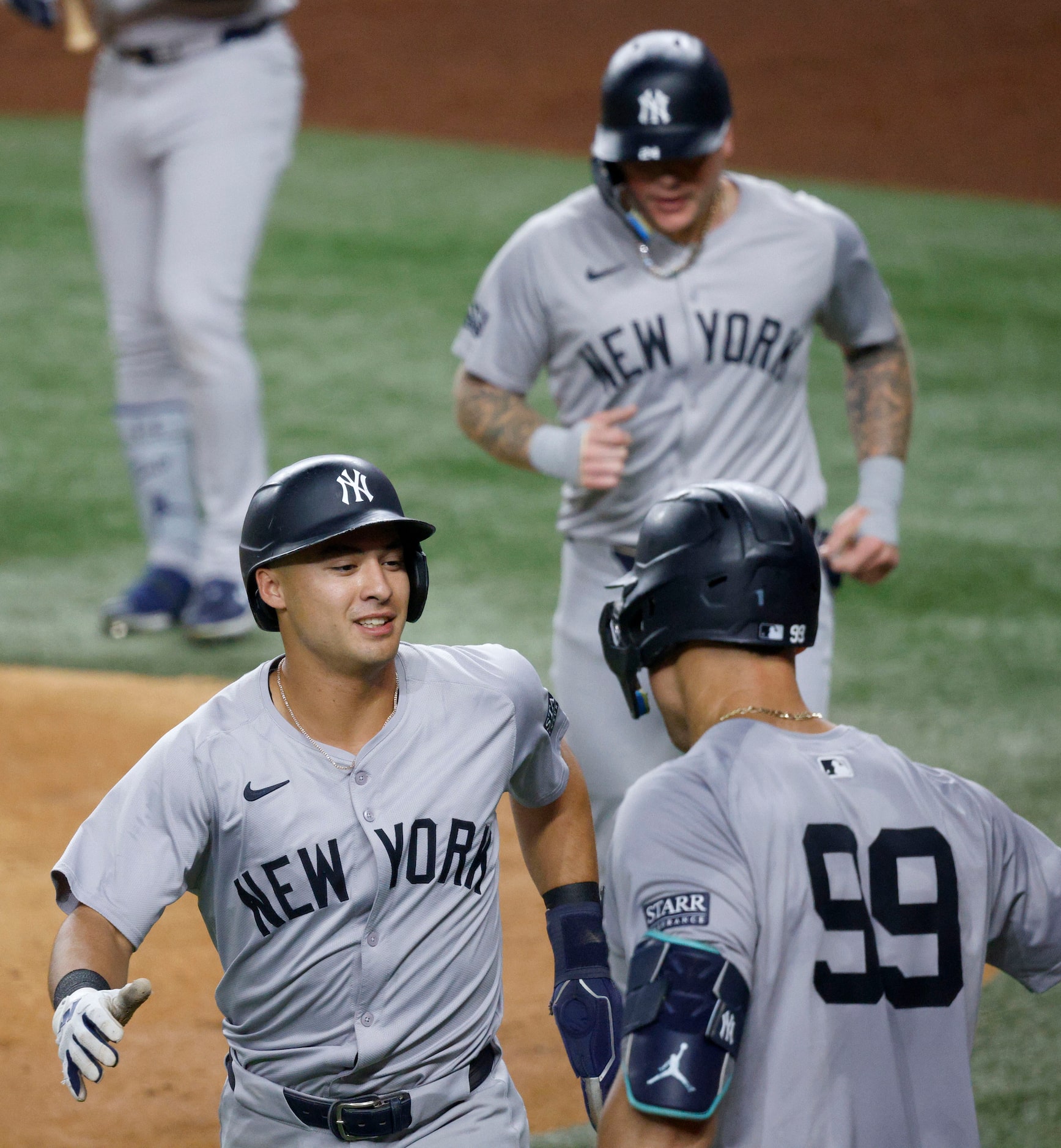 New York Yankees shortstop Anthony Volpe (11), left, smiles to New York Yankees outfielder...