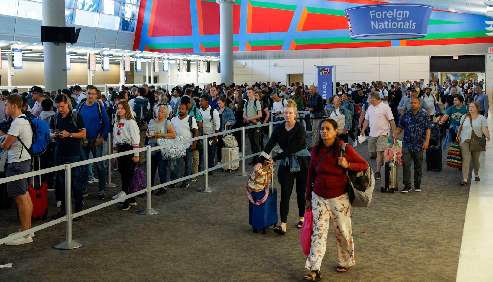 International travelers stand in line at a U.S. Customs and Border Protection checkpoint...
