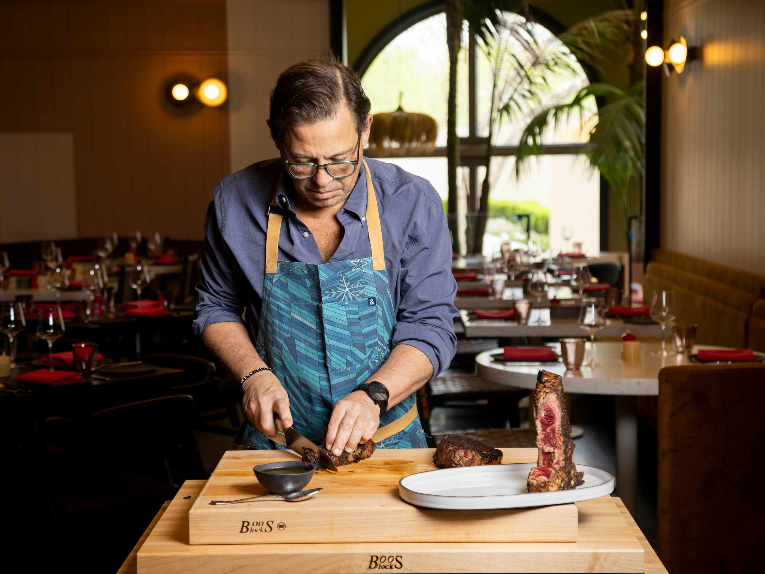 Chef John Tesar carves into a Bistecca a la Las Colinas, a 48-ounce 44 Farms dry-aged...