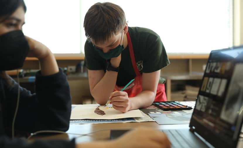 Dallas Academy student Ellis Adatto (center) works on a painting of a bald eagle during...