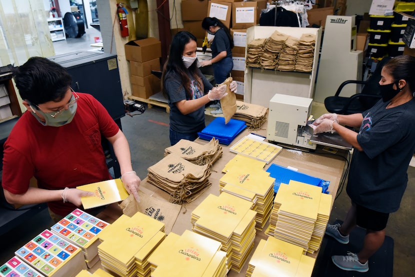 Versa employees add final touches to the lotería playing cards before shipping.