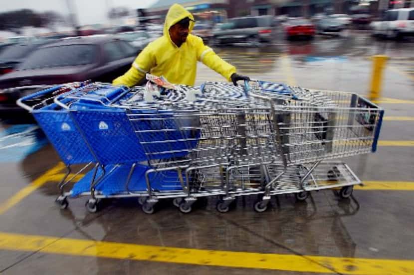 ORG XMIT: *S18F86D72* Sydney Sam pulls in shopping carts in the rain in front of an...