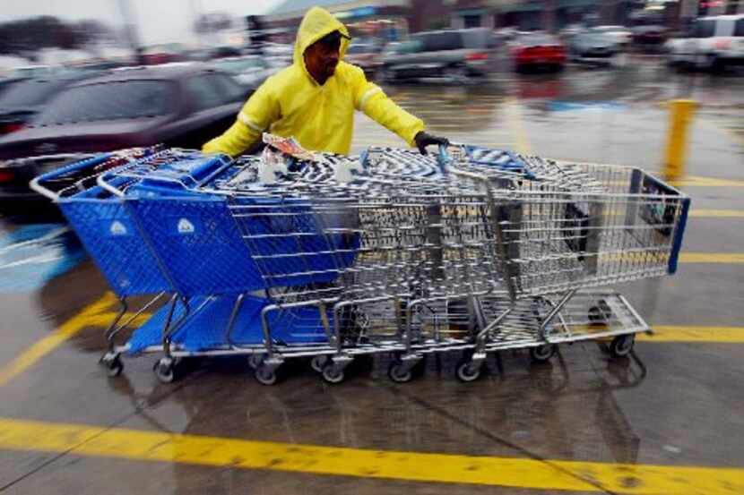 ORG XMIT: *S18F86D72* Sydney Sam pulls in shopping carts in the rain in front of an...