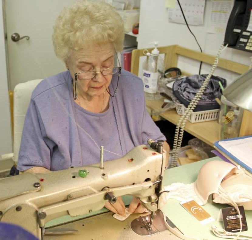 
Longtime worker Martha Pinckley, 81, alters a bra for a customer. Her daughter runs the...