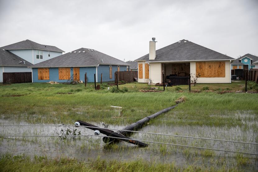 A power line was knocked down during Hurricane Harvey near boarded up homes in Rockport....