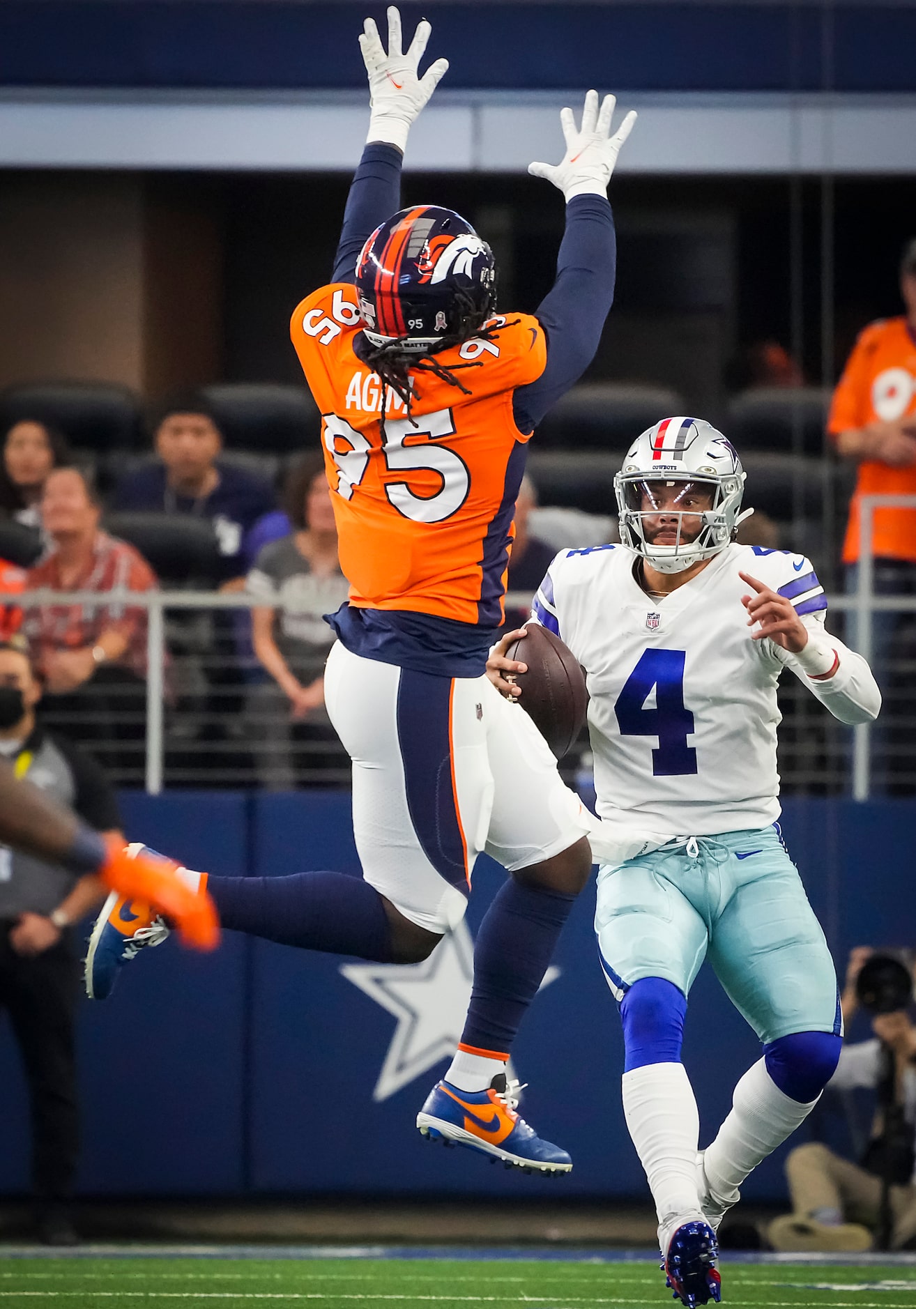 Dallas Cowboys quarterback Dak Prescott (4) looks to pass under pressure from Denver Broncos...