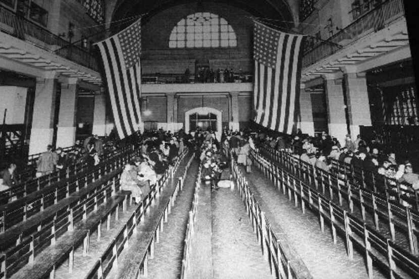 The registry room at Ellis Island, in a 1924 file photo. The site is now visited by tourists...