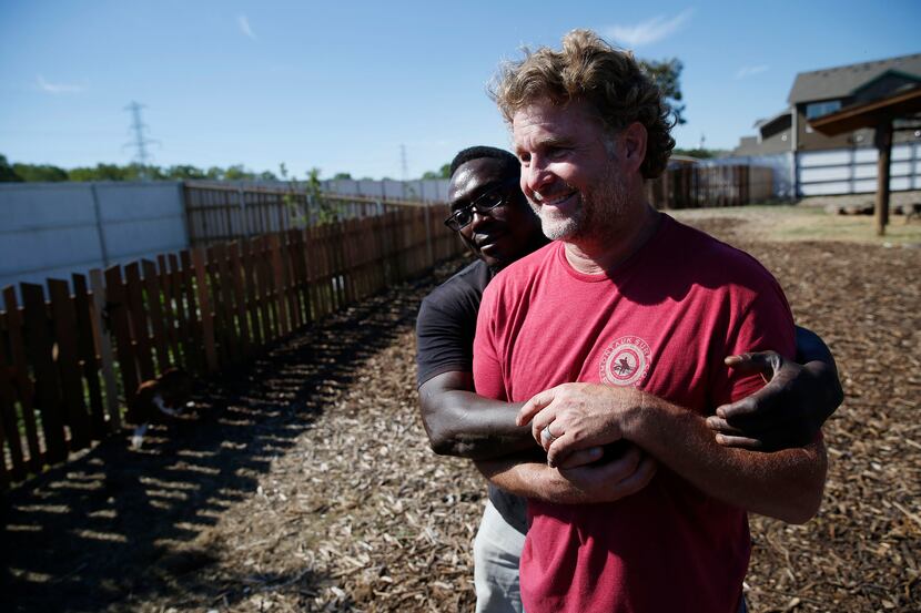  Patrick Wright hugs Daron Babcock after three female pigs were released into their pen at...