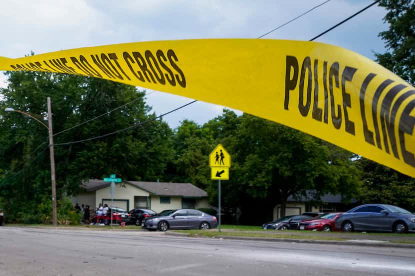 Police tape flutters at the scene scene of a shooting in the 8300 block of Towns St.  in...