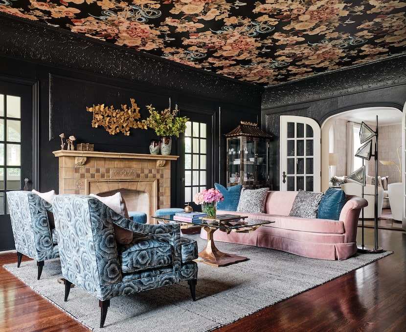 Two patterned upholstered chairs and a large pink couch face each other atop a large...