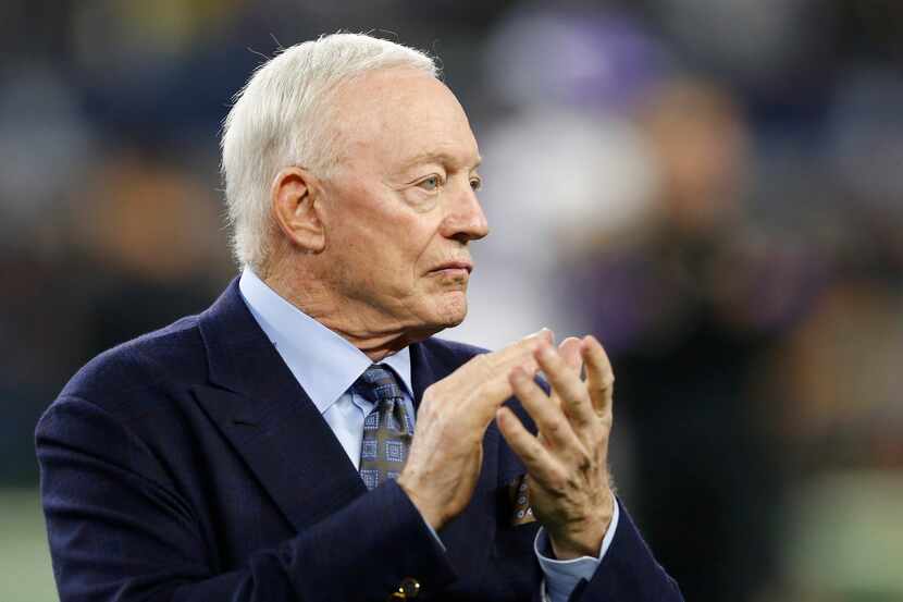 Dallas Cowboys owner Jerry Jones claps as the team takes the field for warmups before a game...