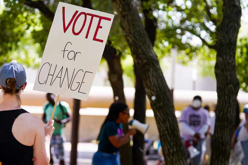 A woman held a sign reading "Vote for Change" during a rally organized by Not My Son at...