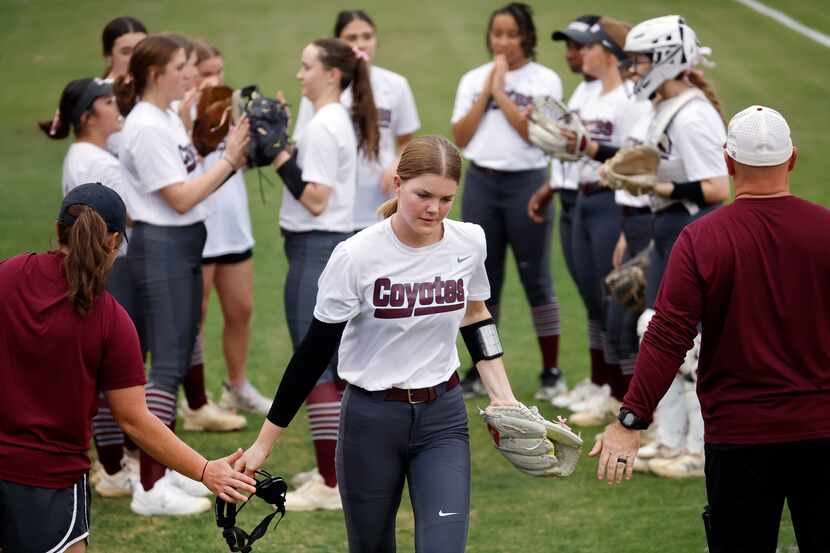 Frisco Heritage starting pitcher Jensin Hall slaps gloves with coaches as she is introduced...