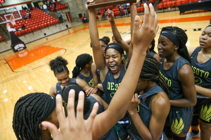 DeSoto guard Ash'a Thompson (25) hoists the trophy after defeating South Grand Prairie 51-34...