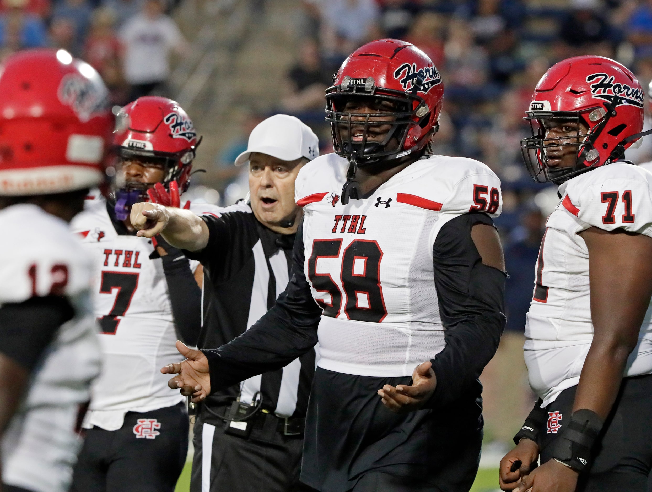 Cedar Hill High School offensive lineman Devin Coleman (58) gets direction from a ref during...