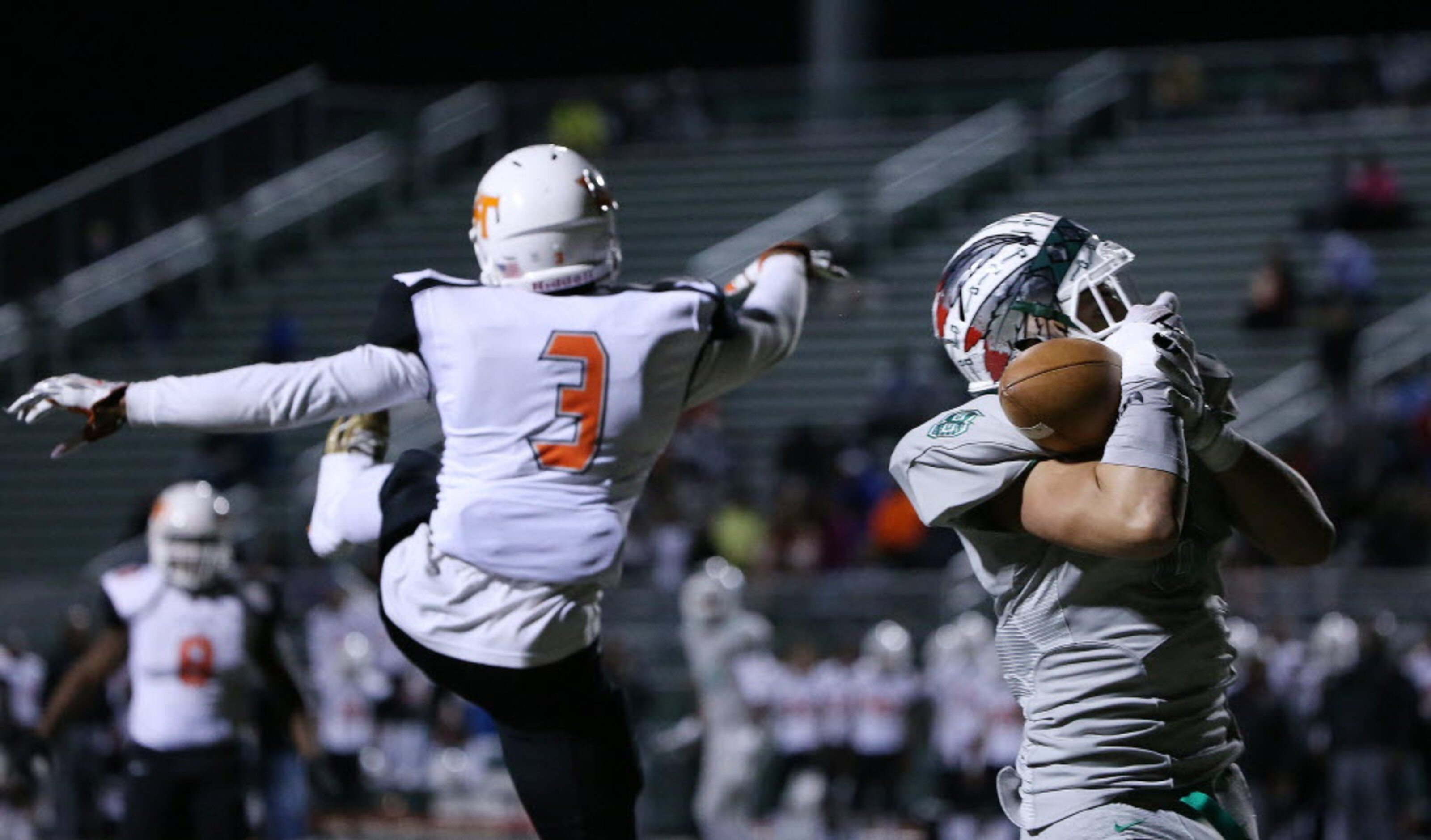 Waxahachie wide receiver Devan Brady (8) catches a pass over Kenan Ivy (3) in the first...