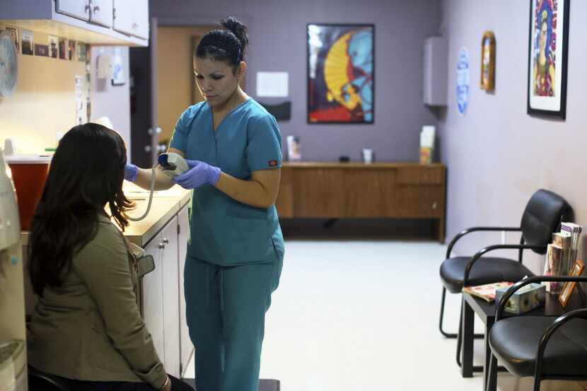 FILE -- Nyla Munoz, a medical assistant, helps a patient through a pre-op appointment during...