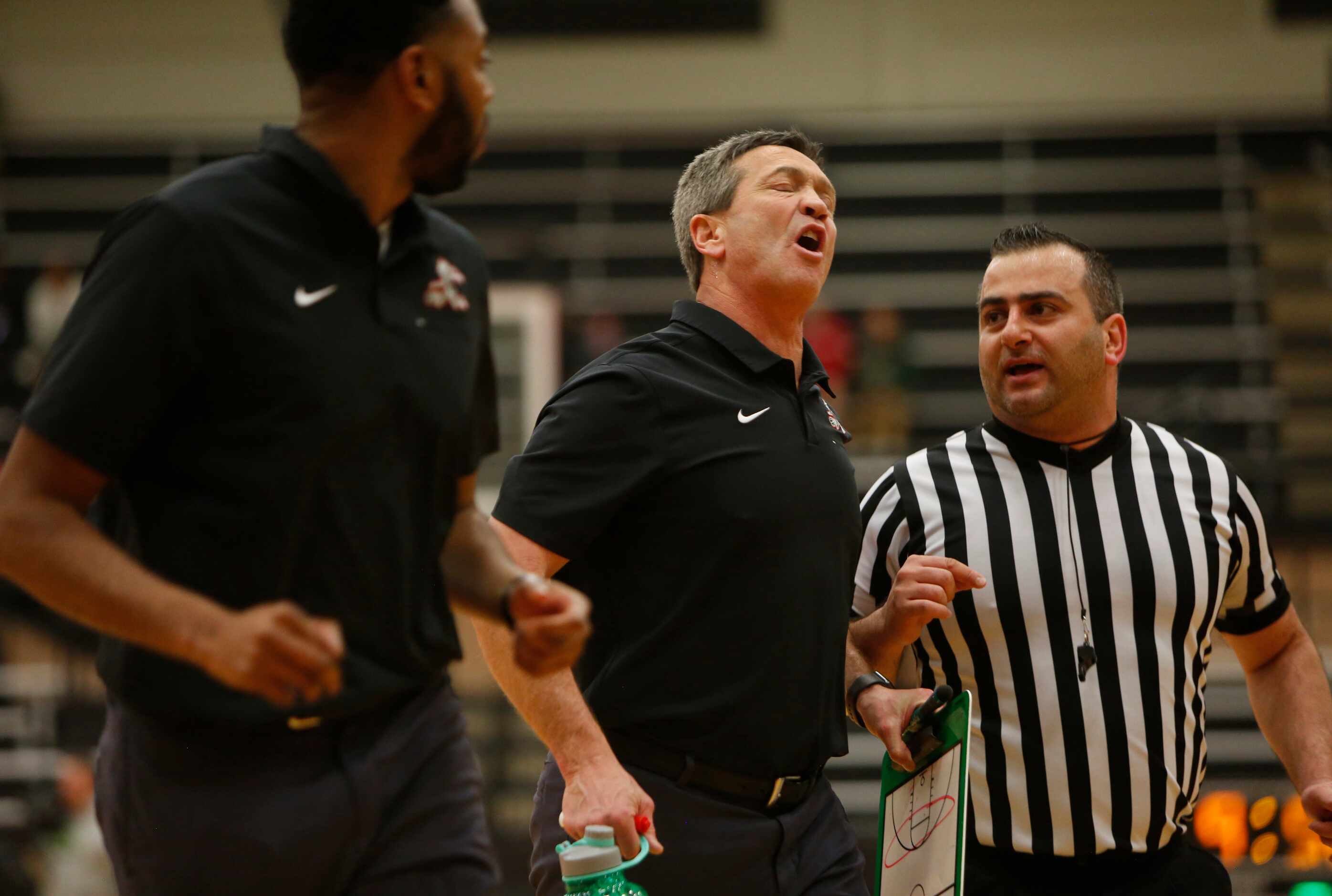 Waxahachie head coach Greg Gober, center, expresses his feelings on a first half call to a...