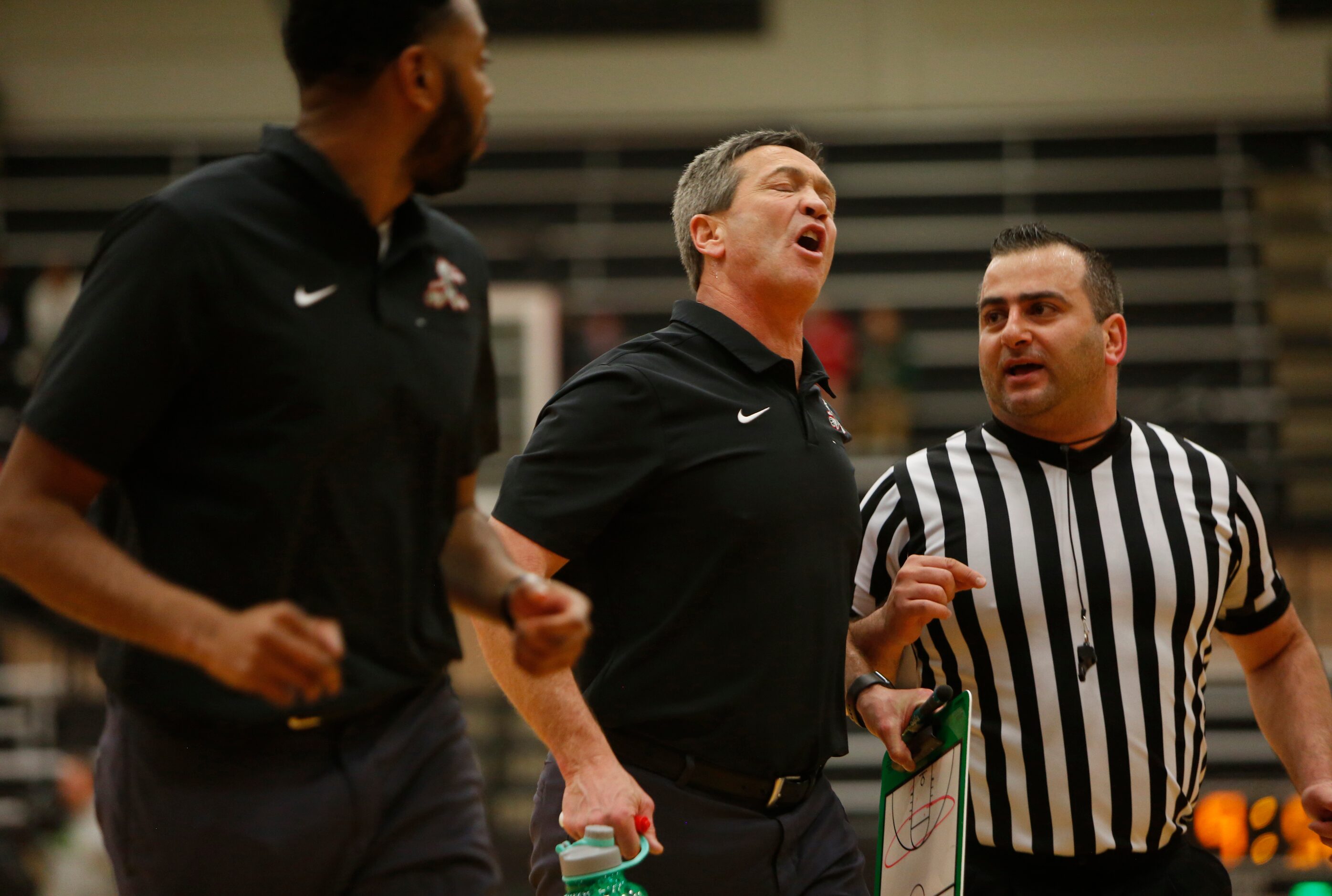 Waxahachie head coach Greg Gober, center, expresses his feelings on a first half call to a...