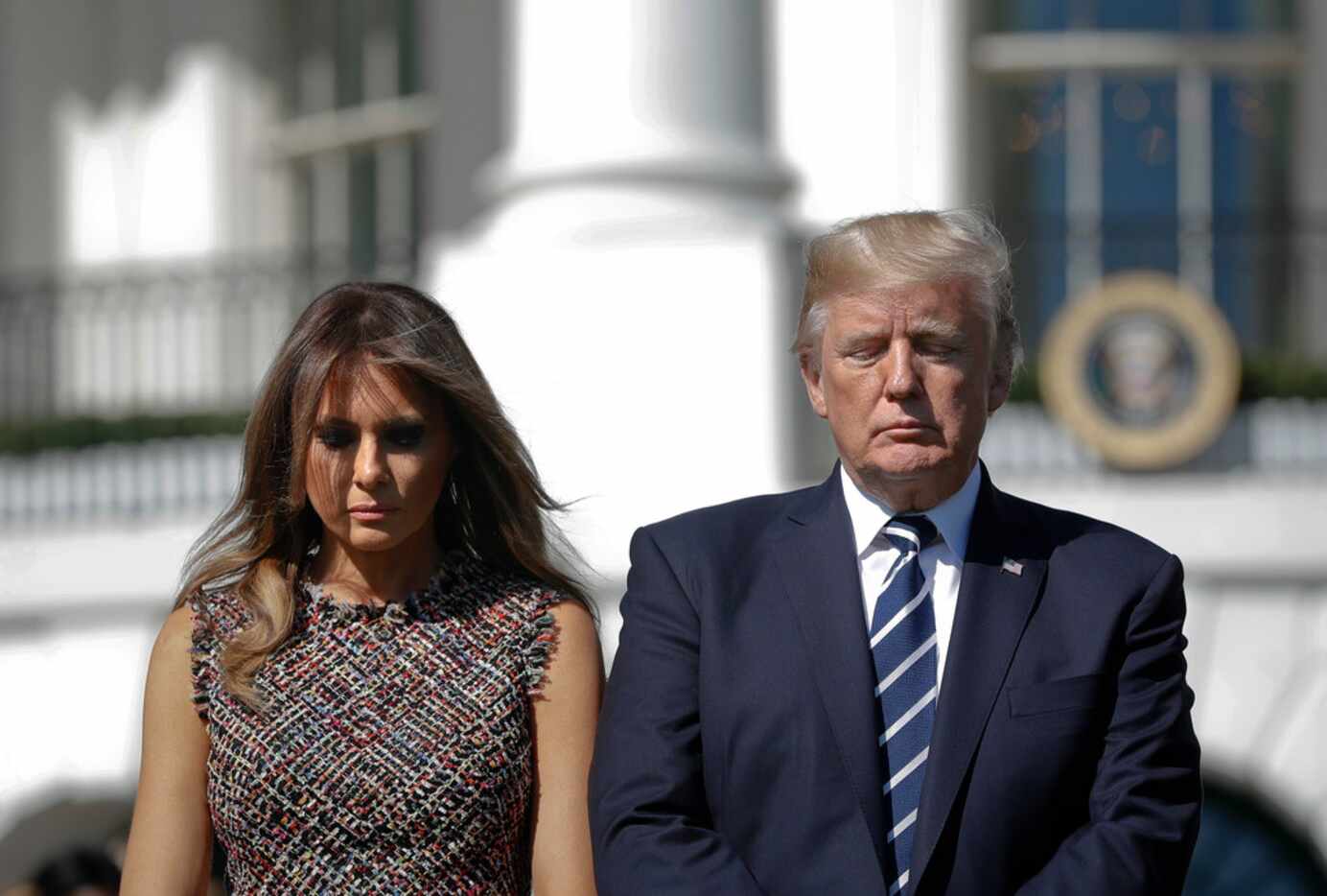 President Donald Trump and first lady Melania Trump stand during a moment of silence to...