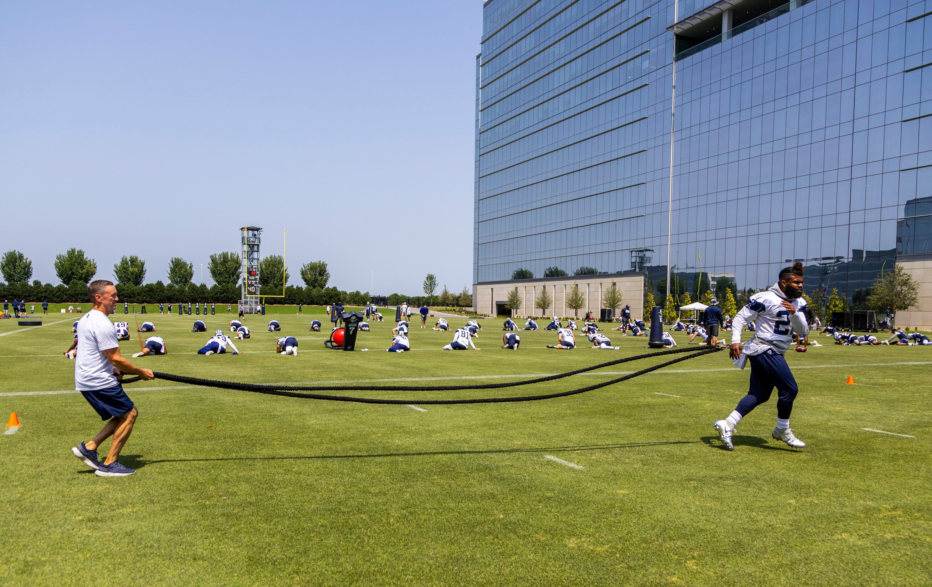 Dallas Cowboys running back Ezekiel Elliott, right, runs a drill during practice at The Star...