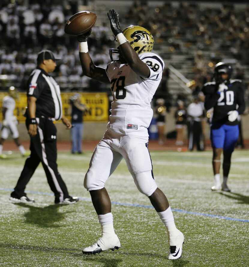 Plano East running back Desmond Bowden (28) celebrates after scoring a rushing touchdown to...