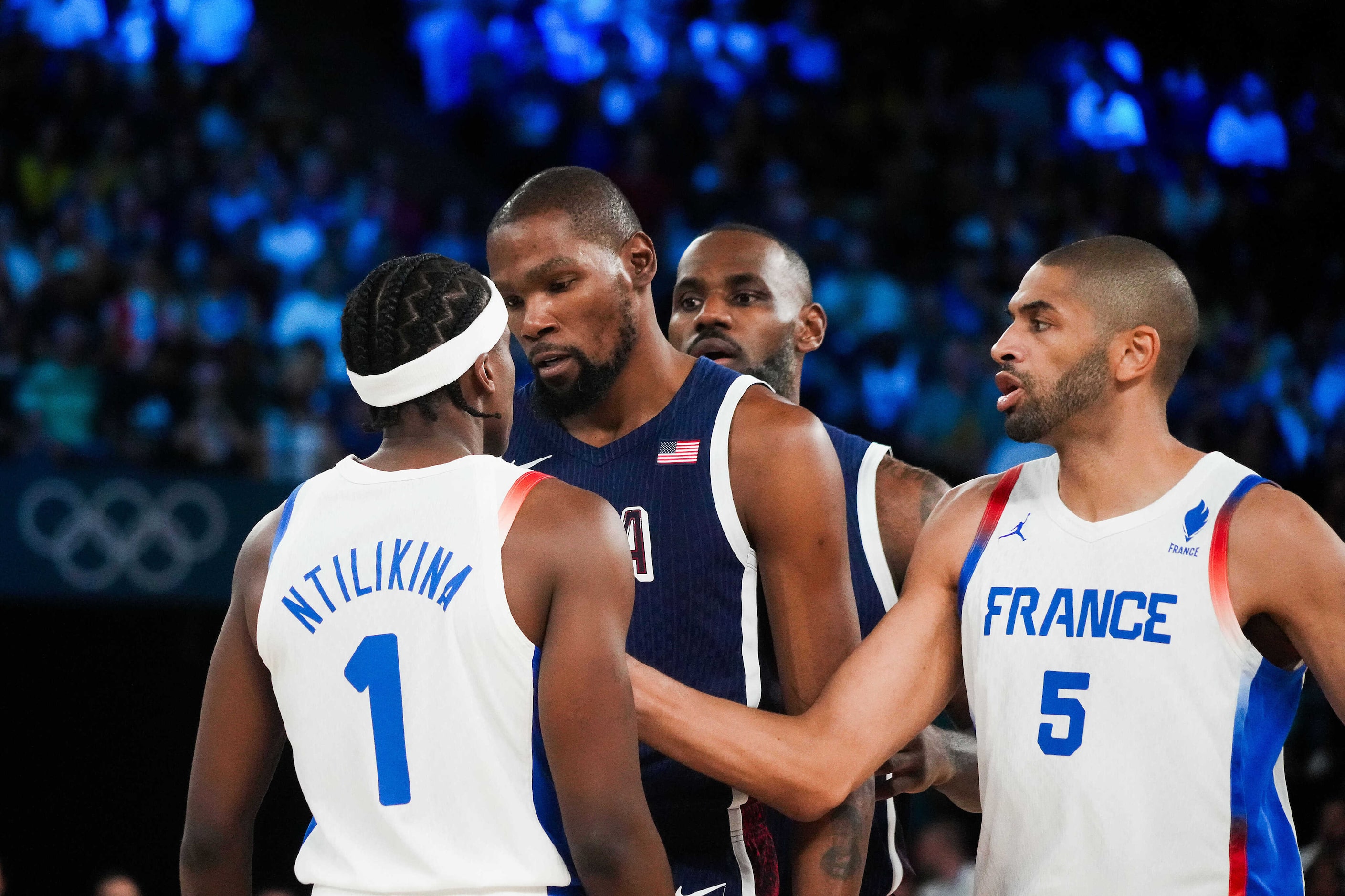 Nicolas Batum (5) of France steps in to separate teammates Frank Ntilikina (1) from Kevin...