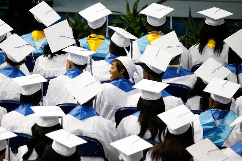 Graduates look for their parents in the audience during the Wilmer-Hutchins High School...