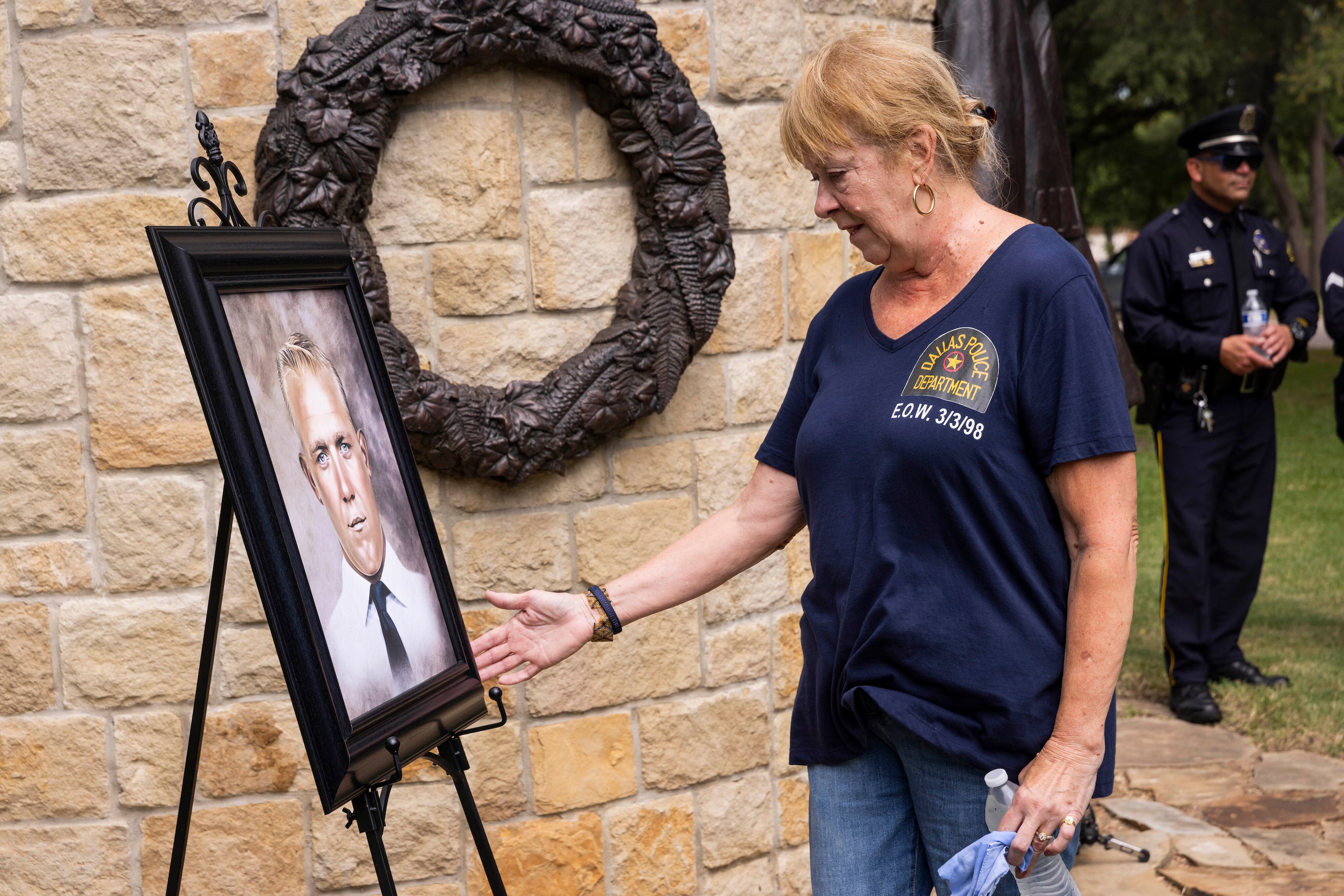 Kimberly Black reaches out to touch a portrait of her father Sgt. Claude Standridge before...