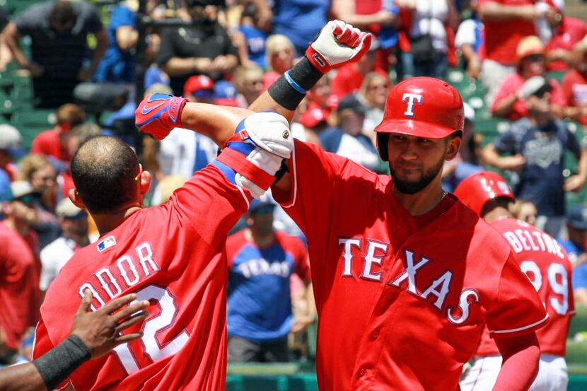 Texas Rangers Rougned Odor (12) celebrates with Nomar Mazara (30) after Mazara homers in the...