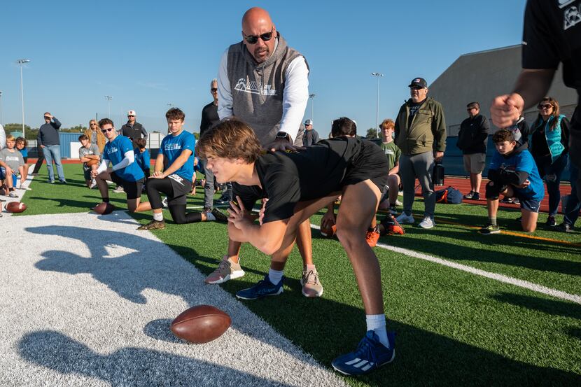 Head trainer Chris Rubio works with long snapper Jax Thompson, of Flower Mound High School,...