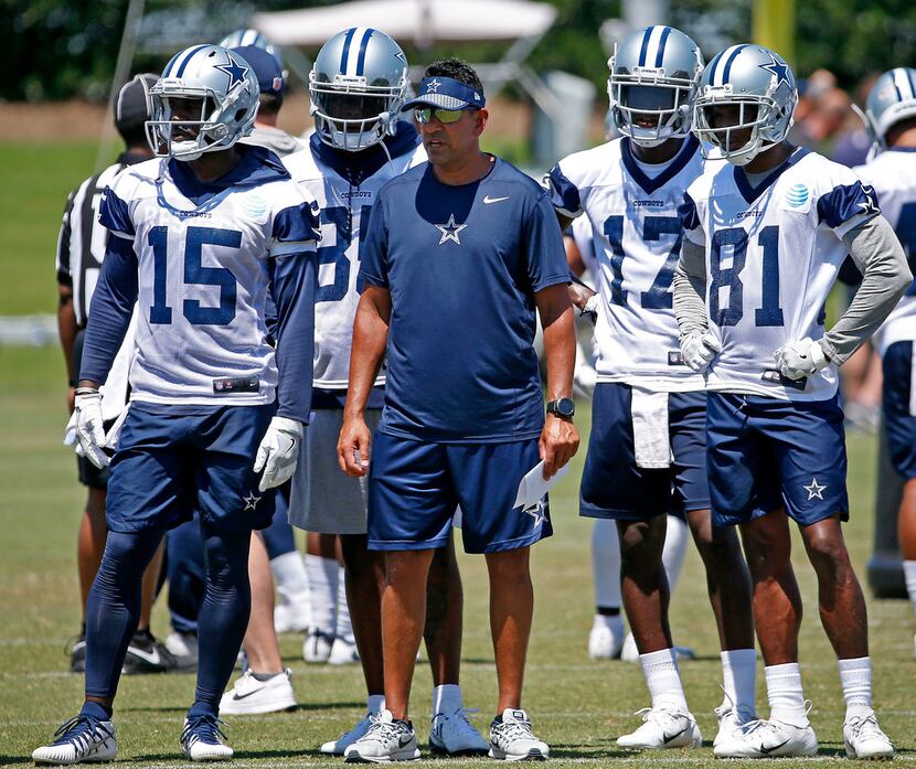 Dallas Cowboys wide receiver coach Sanjay Lal, center, in surrounded by his players Deonte...