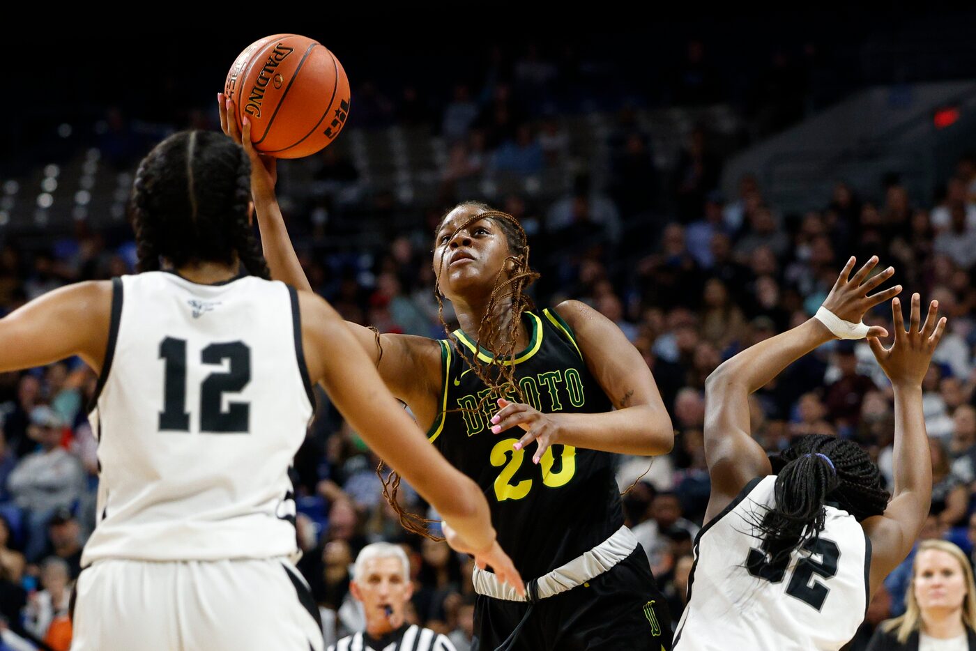 DeSoto guard Ayanna Thompson (20) attempts a layup in between San Antonio Clark center...