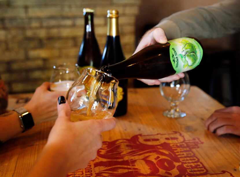 Beer lovers at the Bearded Lady in Fort Worth share a bomber, a large-format bottle of beer....