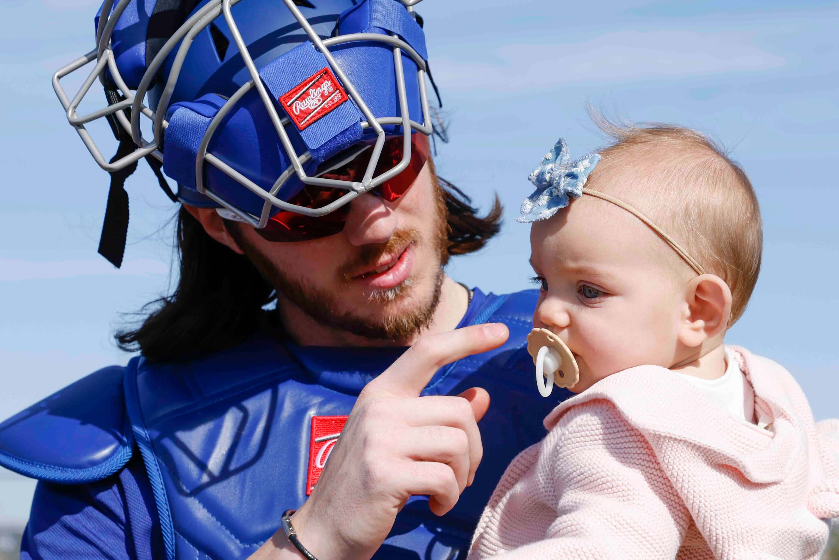 Texas Rangers catcher Jonah Heim holds his nine-month-old daughter Luxx before a spring...