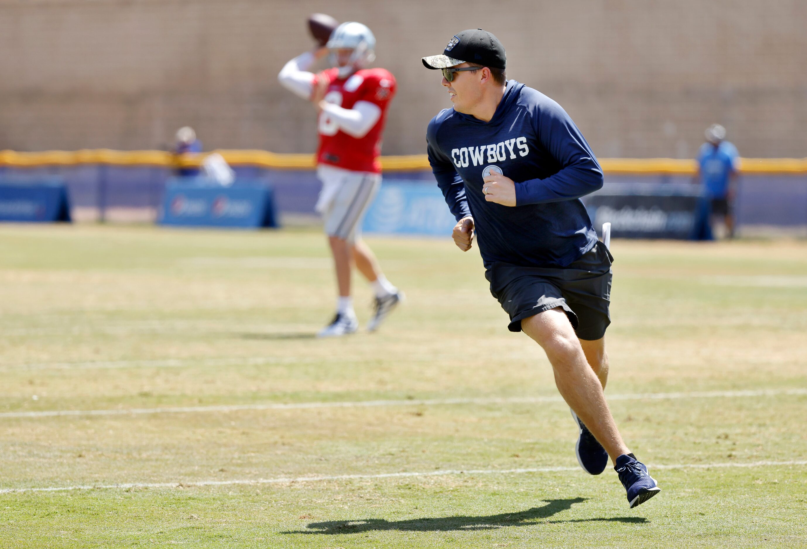 Dallas Cowboys offensive coordinator Kellen Moore (center) runs a pass route during...