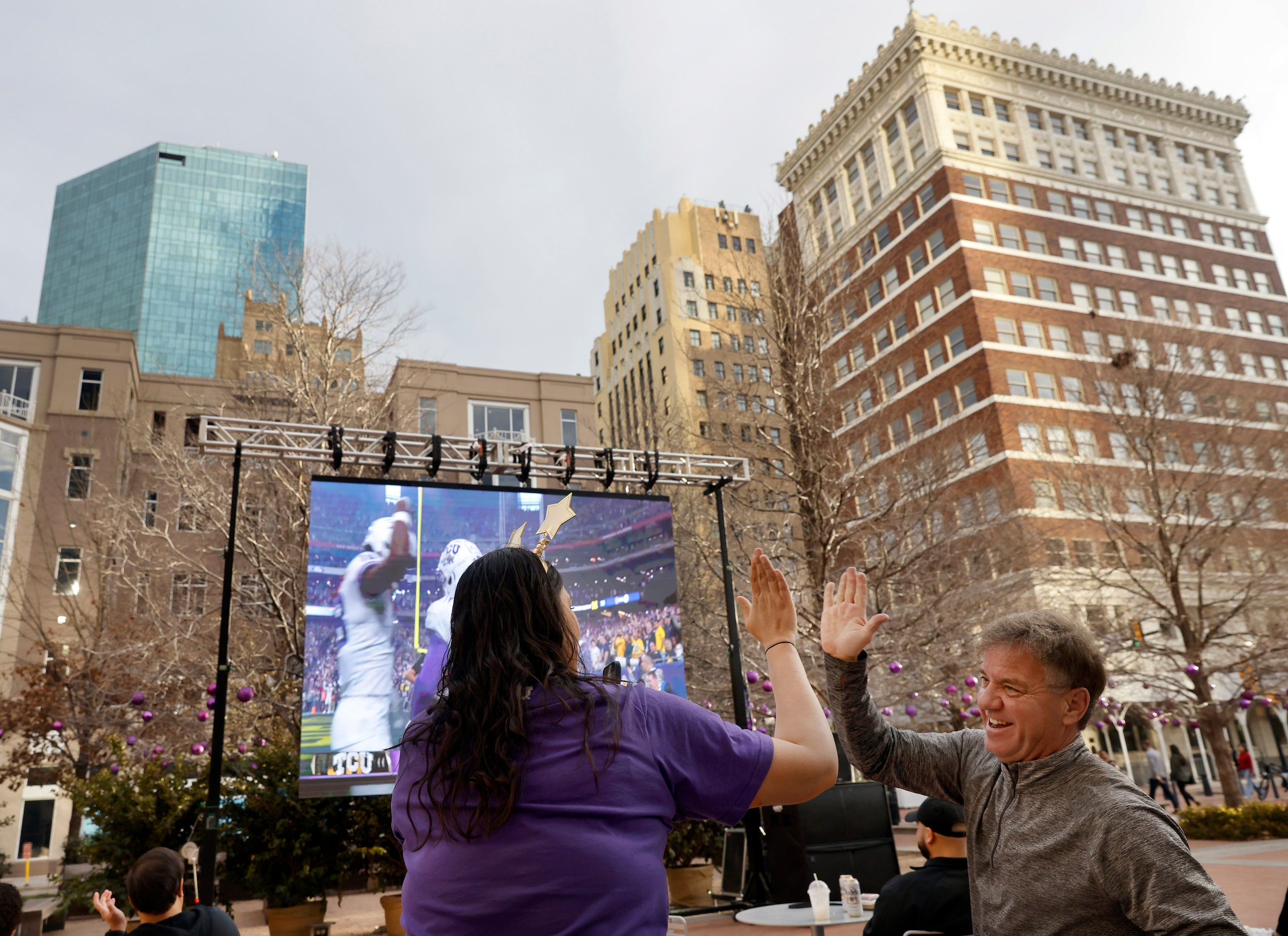 TCU Horned Frogs fans Wardah Iqbal (left) slaps hands with Glenn Stromberg following a first...