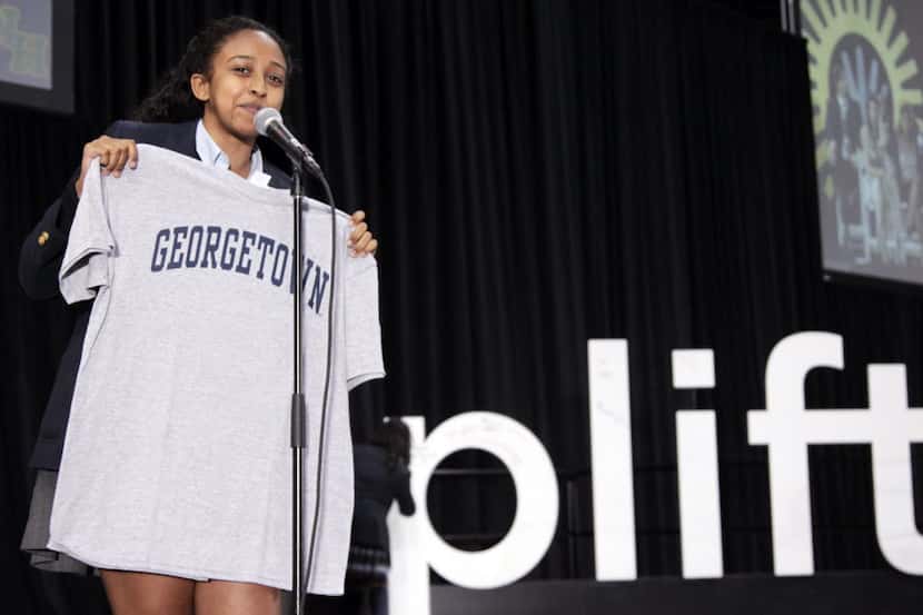An Uplift student holding the jersey of the college she will attend.