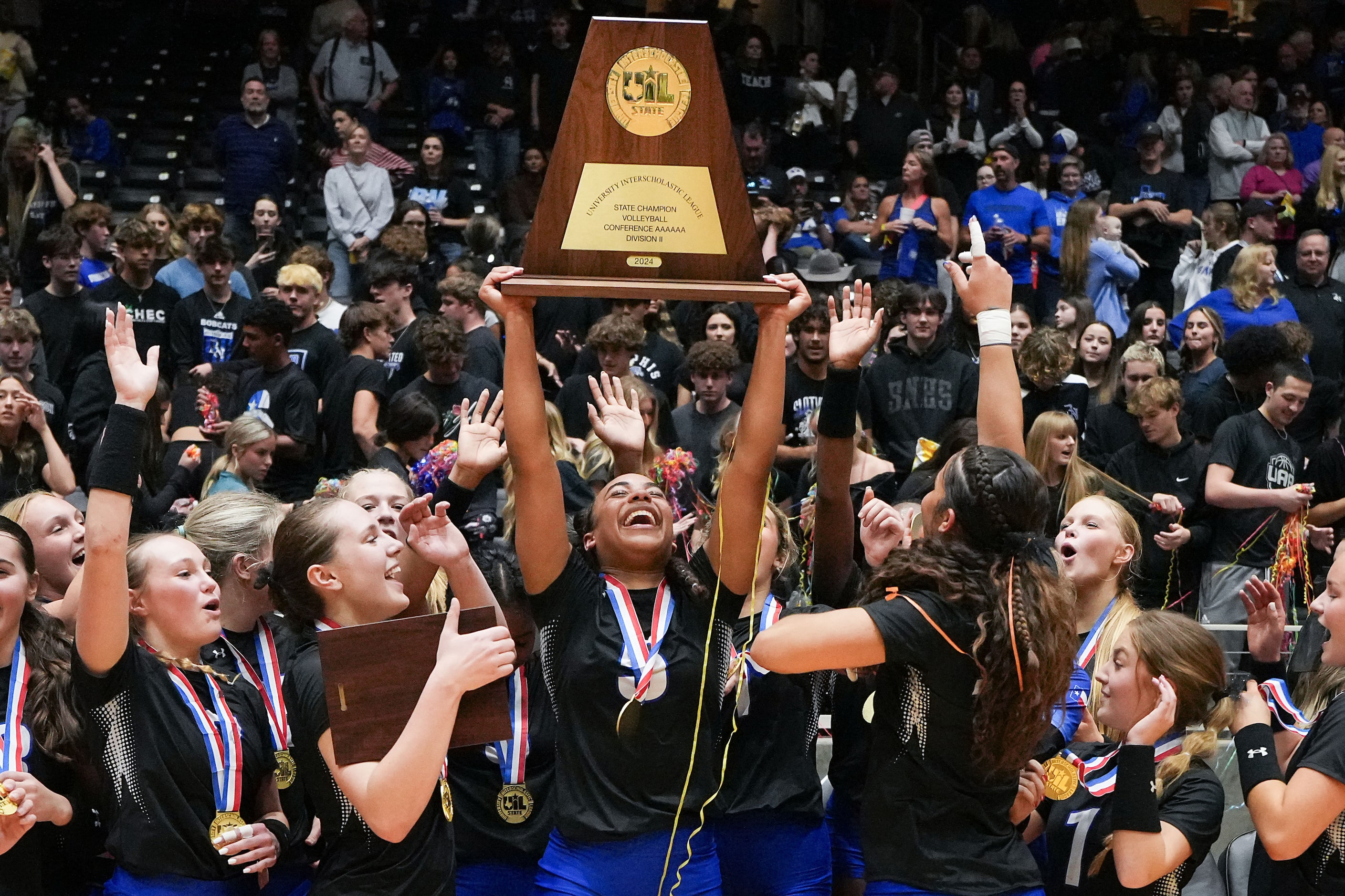 Trophy Club Byron Nelson's Sydnee Peterson  lifts the trophy with teammates as they...