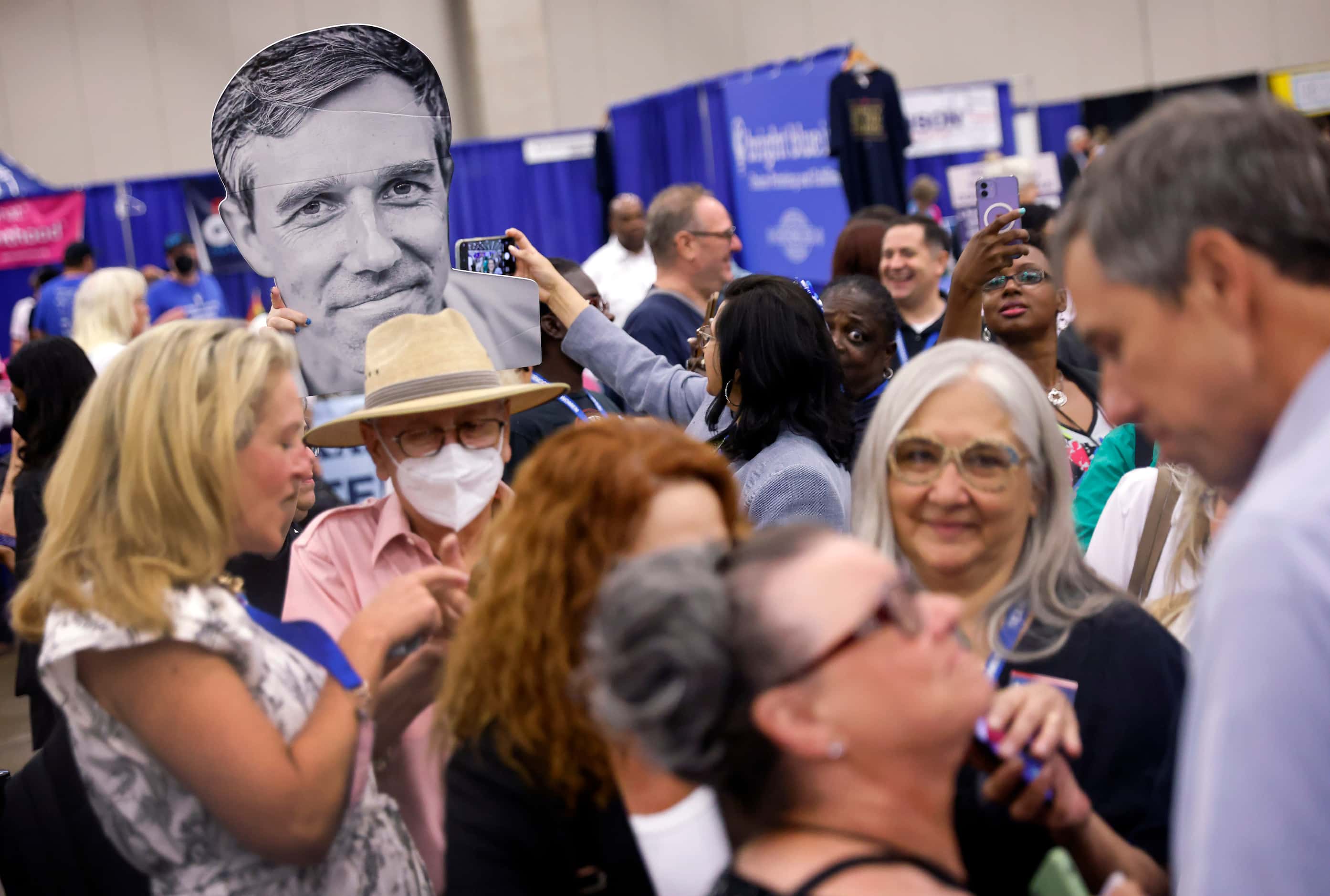 A cutout of Democratic gubernatorial challenger Beto O'Rourke rises above the crowd gathered...