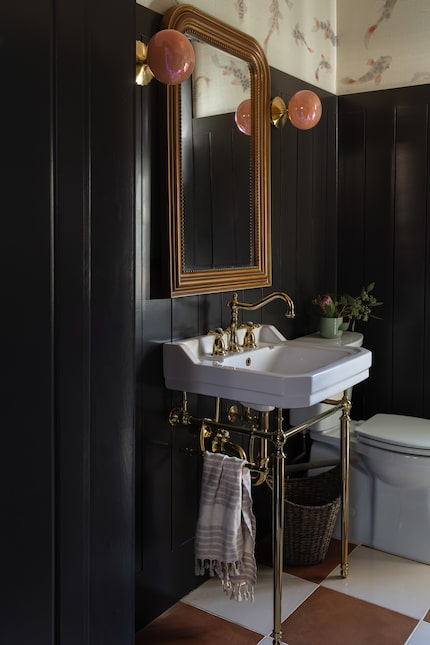 Bathroom sink with blank paneled walls and koi fish wallpaper with a checker-patterned floor