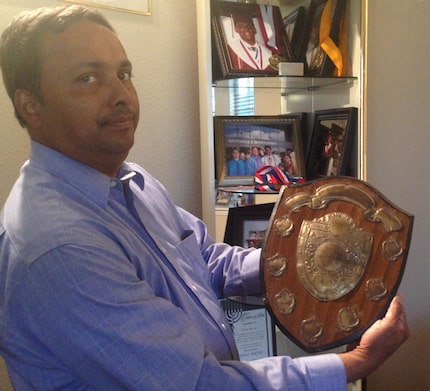 Sunny George shows off the trophy he earned as valedictorian in India. All three of his...