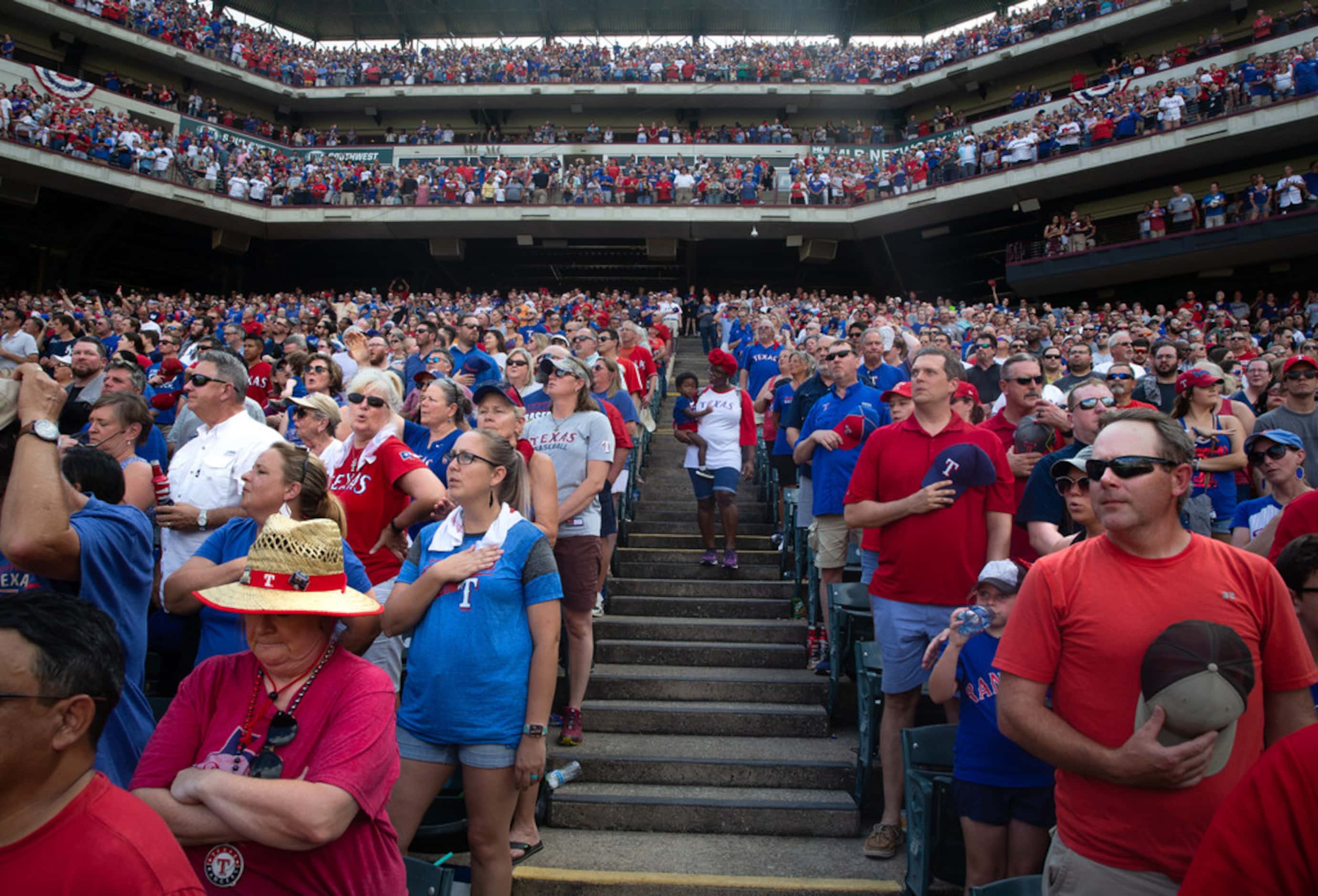 Fans stand to sing God Bless America during the 7th inning during the Texas Rangers' final...