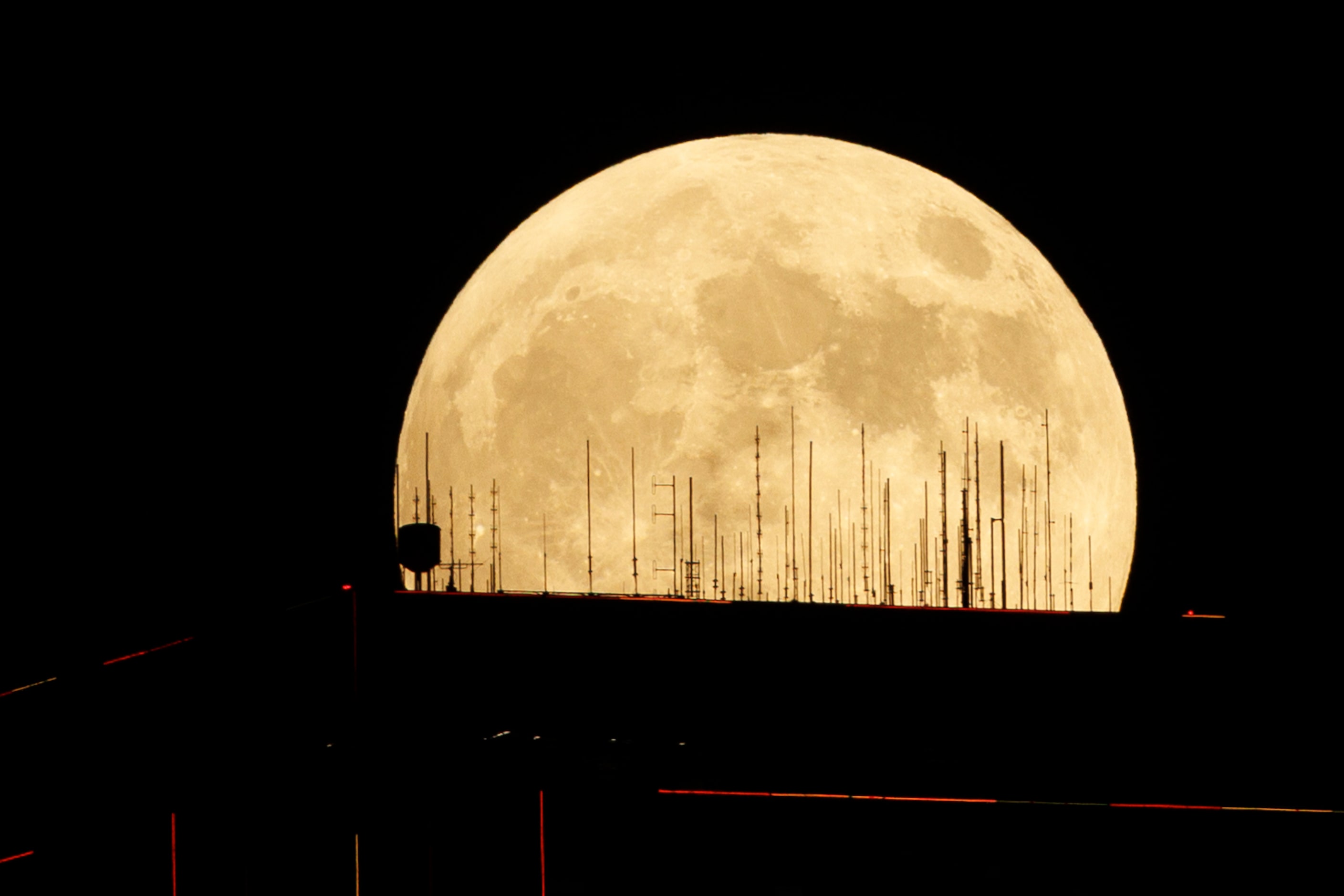 A partial lunar eclipse and supermoon is seen over Bank of America Plaza in downtown Dallas,...