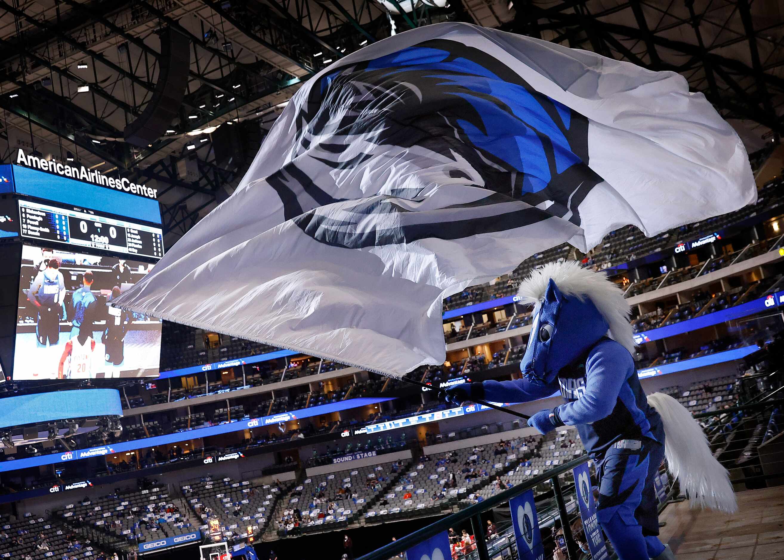 Dallas Mavericks mascot Champ waves the team flag over fans before the team faces the...