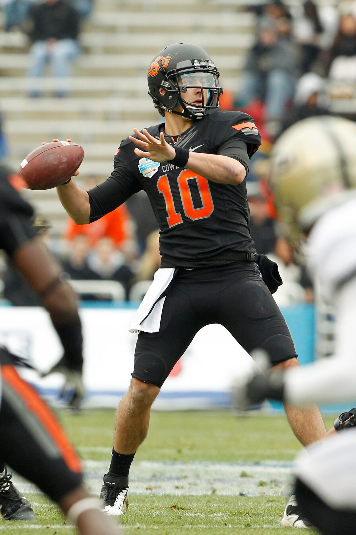 Oklahoma State's Clint Chelf (10) looks for an open receiver during the inaugural Heart of...