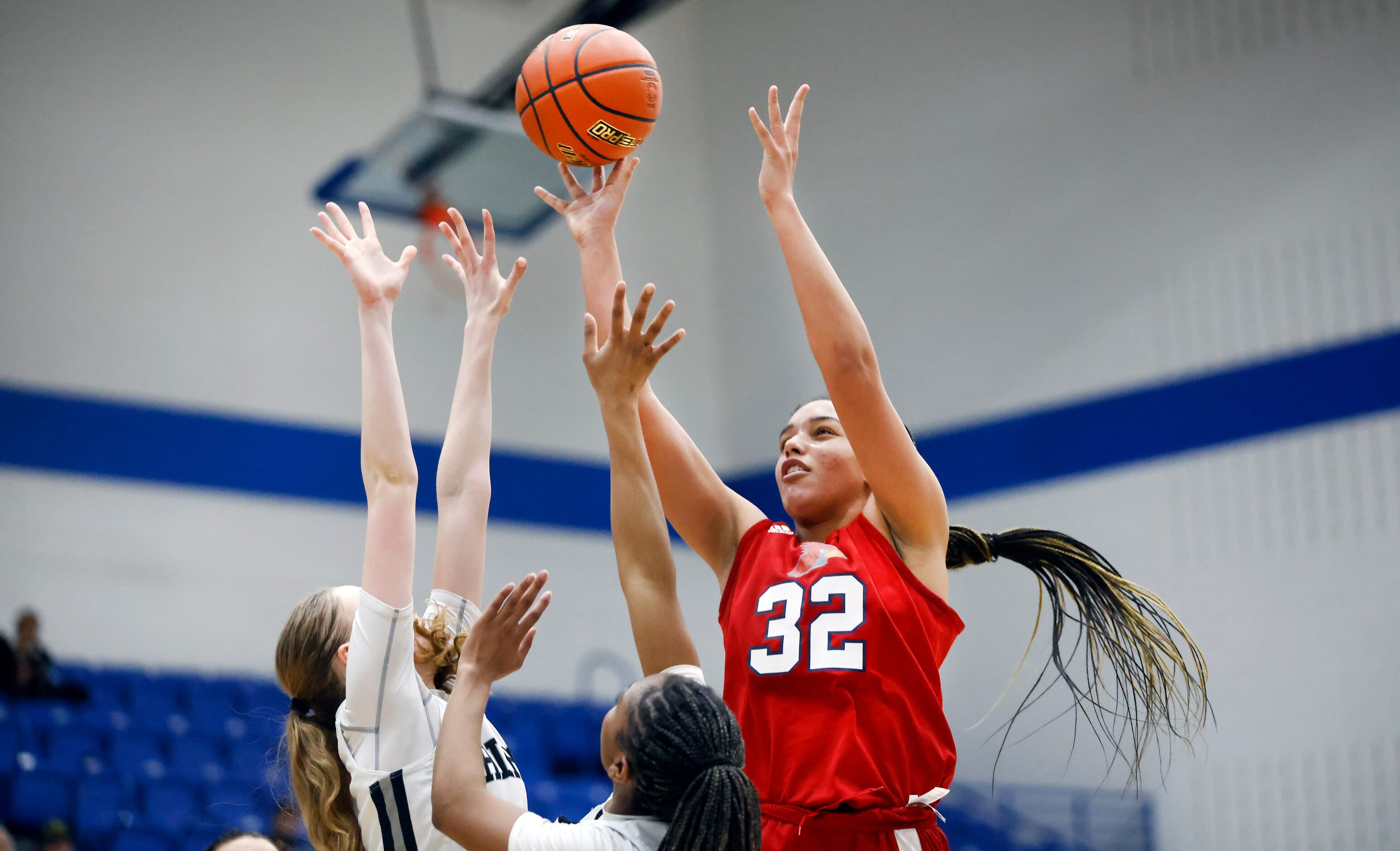 John Paul II forward Allysia McDaniel (32) puts up a shot over a pair of Bishop Lynch...