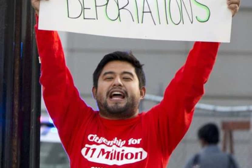 
A protester held up a sign in support of immigration reform outside an event attended by...