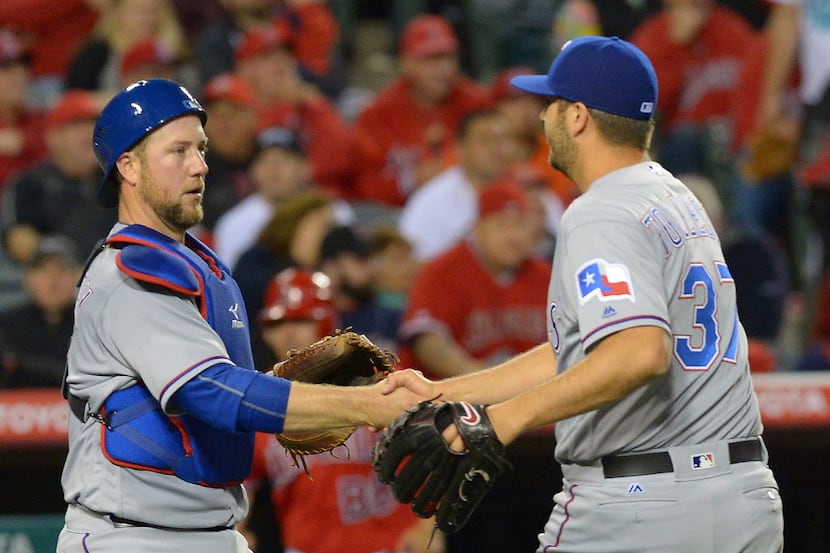 Apr 9, 2016; Anaheim, CA, USA; Texas Rangers catcher Bryan Holaday (8) shakes hands with...